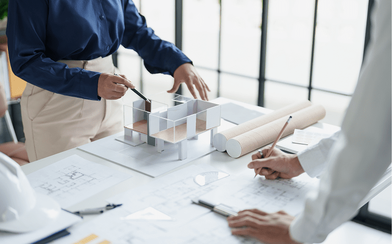 Architects reviewing construction plans and model